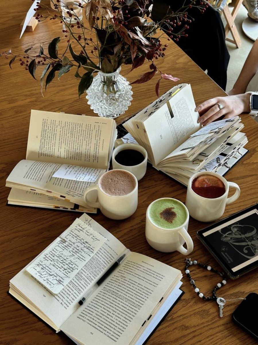 Women reading together while enjoying hot drinks.