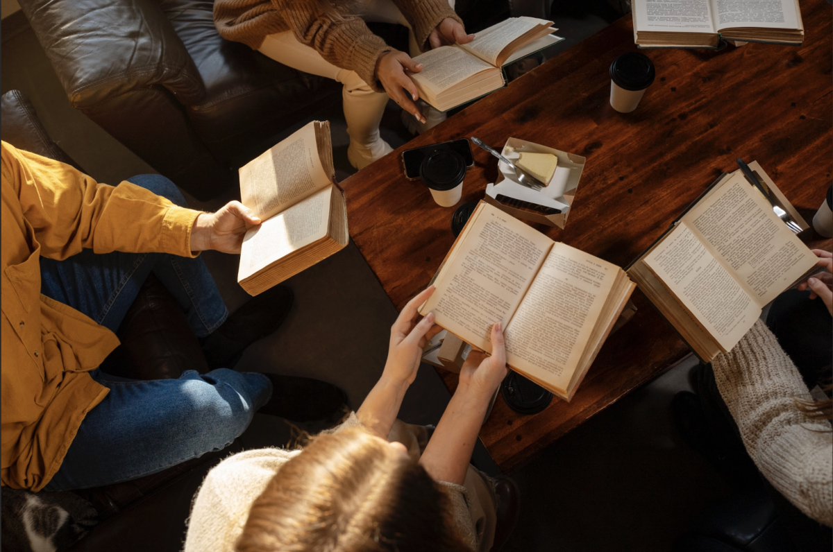 People reading together over coffee. (Photo via: Freepik).